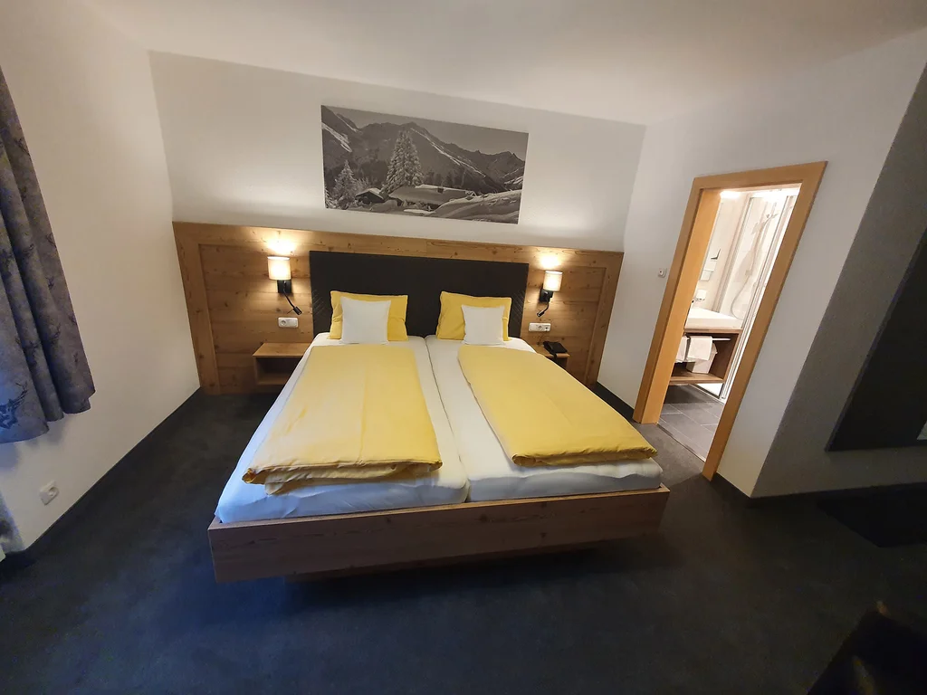 Doppelzimmer im Hotel Dorfblick mit Doppelbett und Holzverkleidung