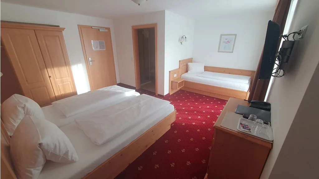 Dreibettzimmer im Hotel Dorfblick mit Holzmöbeln