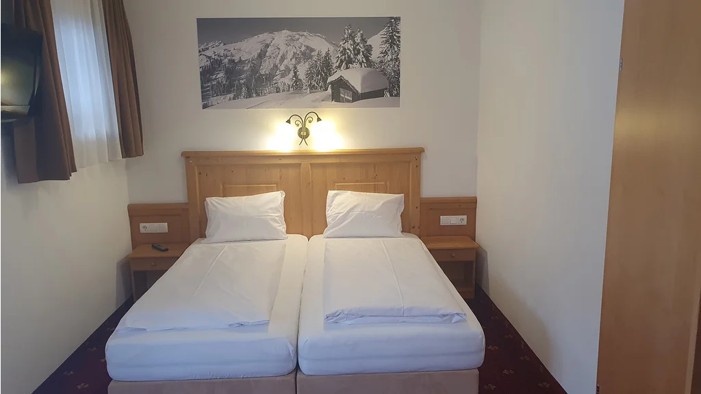Appartement 21: Schlafzimmer mit Doppelbett und Arlberg-Bild